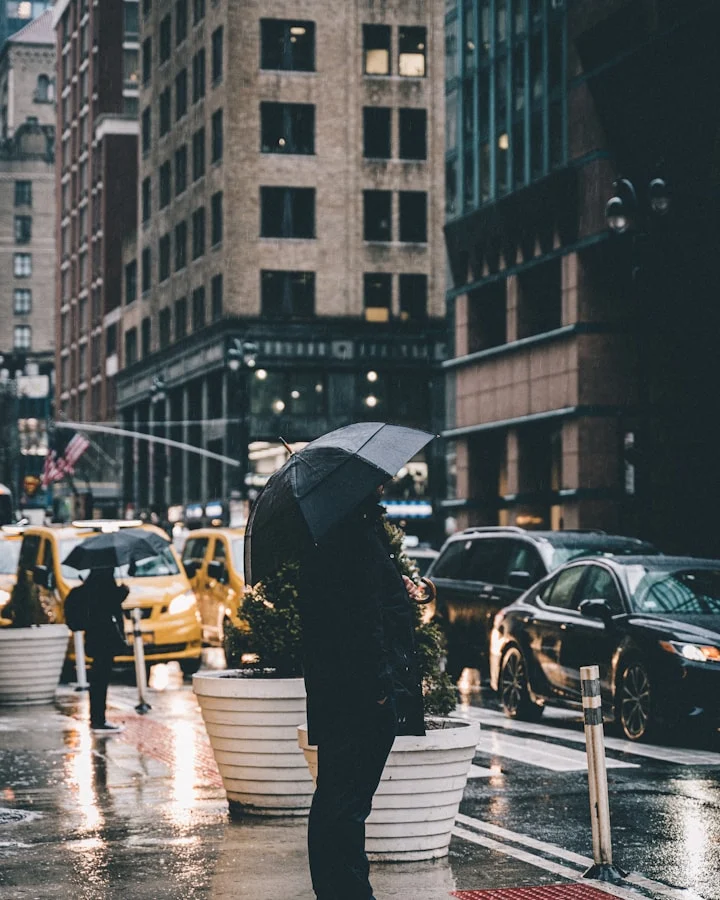 An umbrella on a rain-soaked city street, with yellow taxis in the distance